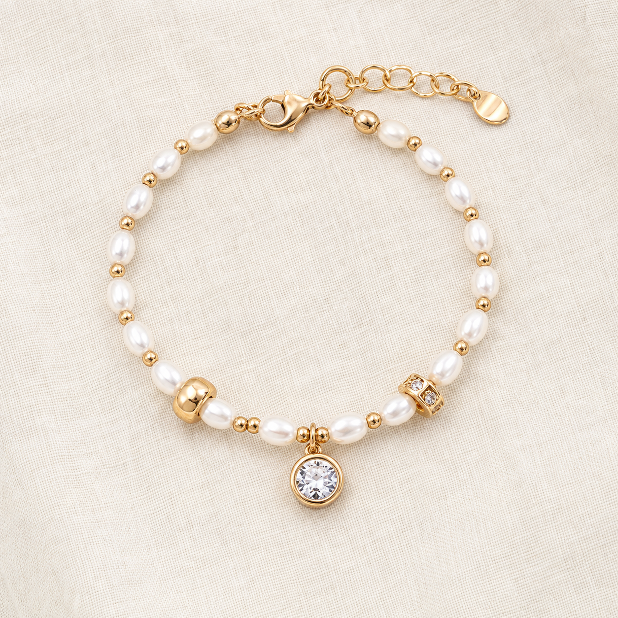 Full view of the Vintage Gold natural pearl charm bracelet on textured fabric