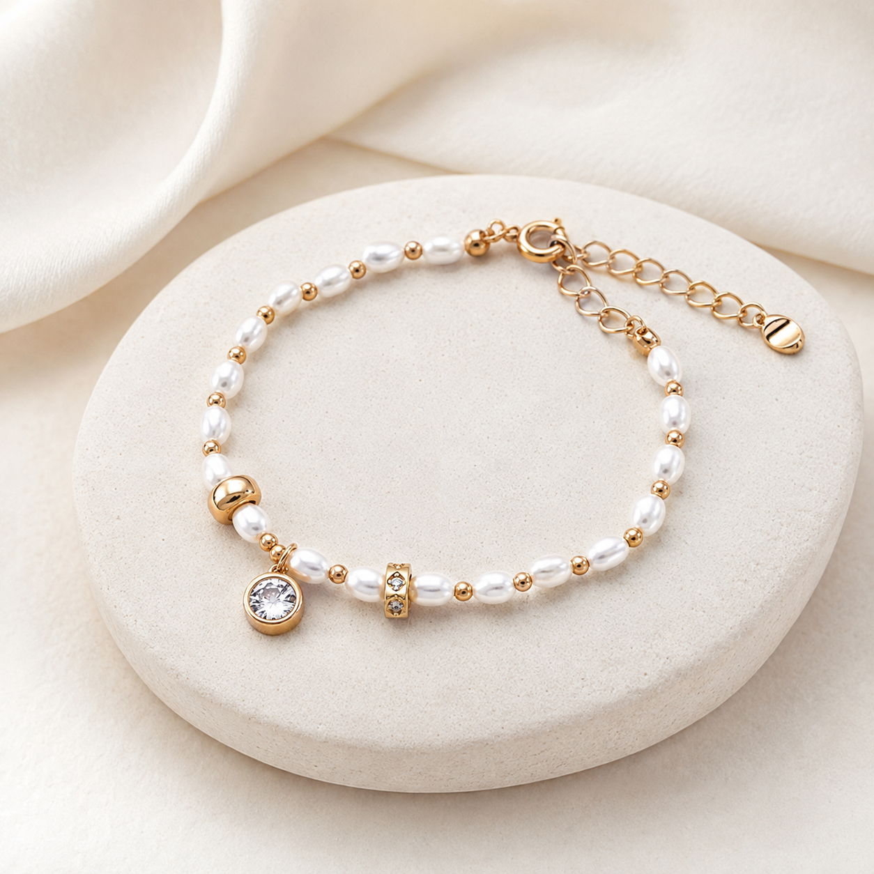Vintage Gold pearl and cubic zirconia charm bracelet on a stone display