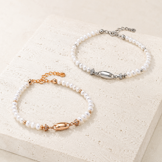 Vintage Gold and Silver natural pearl fish bracelets shown together on an ivory display