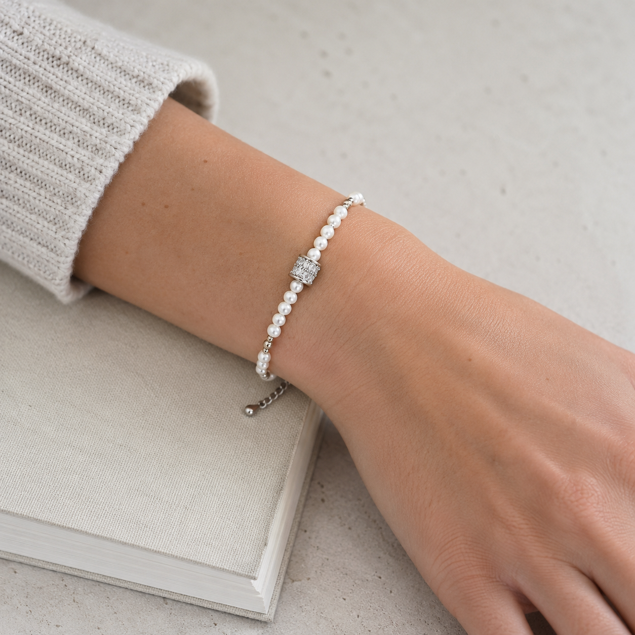 Model wearing the Silver Fortune Turn Pearl Bracelet with a neutral sleeve