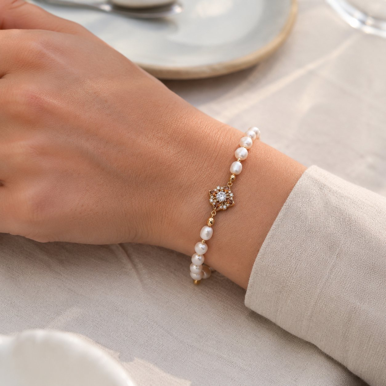 Close wrist view of the Vintage Gold floral natural pearl bracelet