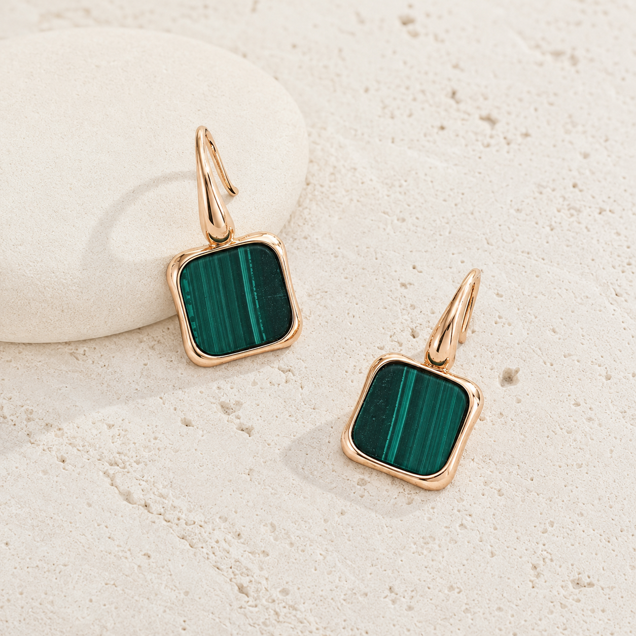 Vintage Gold malachite drop earrings on a textured stone surface