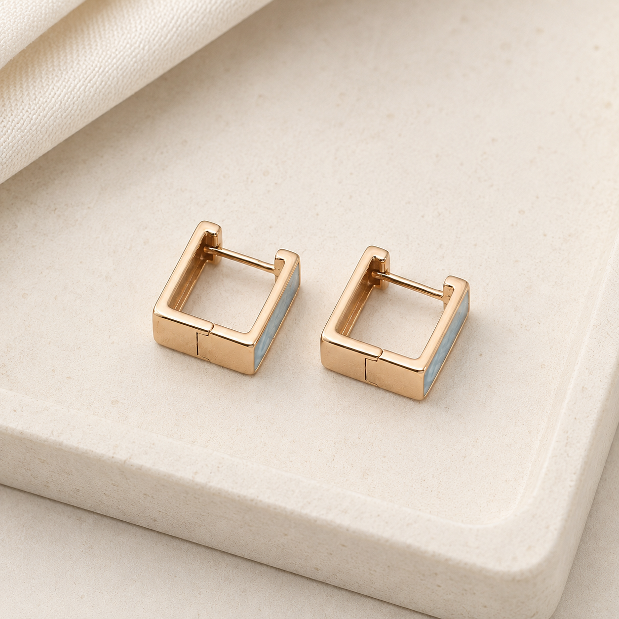 Pair of Vintage Gold French enamel drop stud earrings on a stone display
