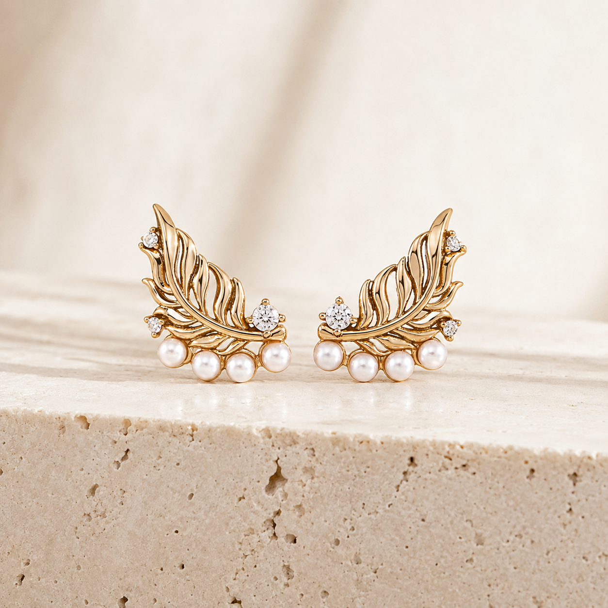 Pair of Vintage Gold feather pearl stud earrings with cubic zirconia on a stone display