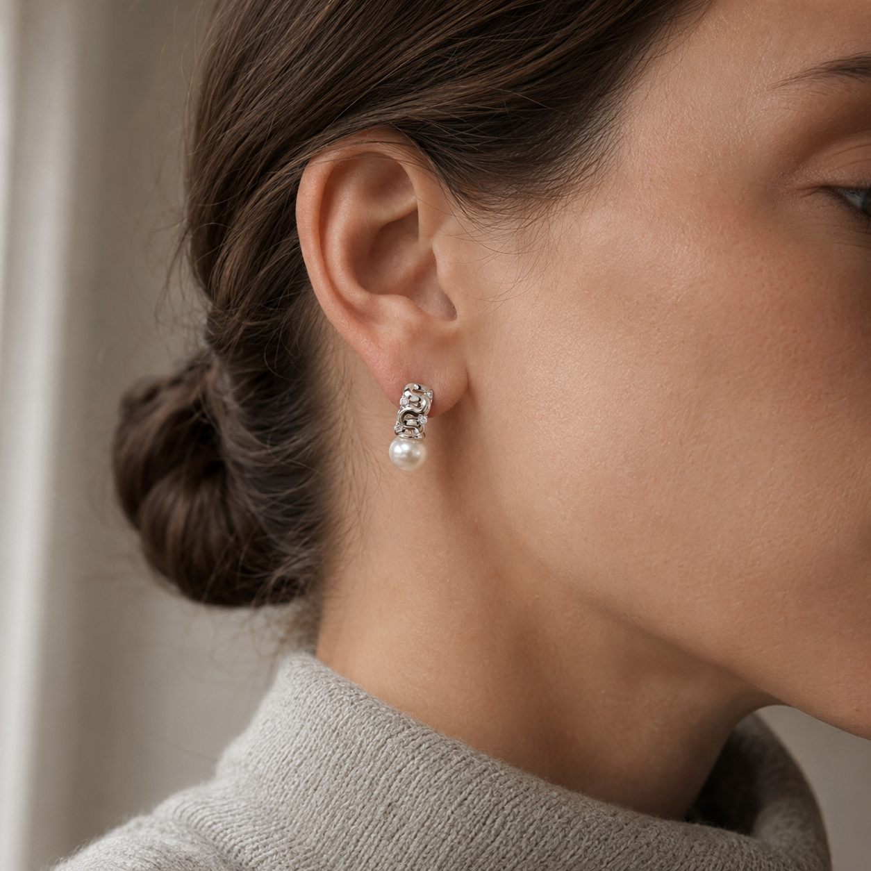 Close ear view of a Silver pearl ribbon stud earring