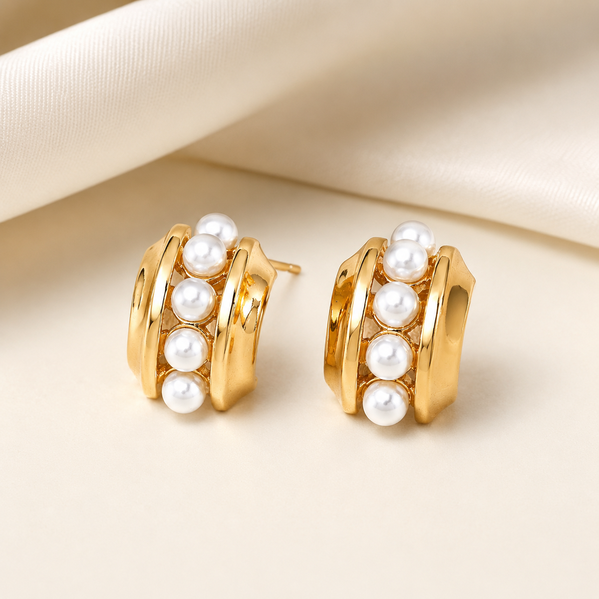 Pair of Vintage Gold layered shell pearl stud earrings on an ivory display