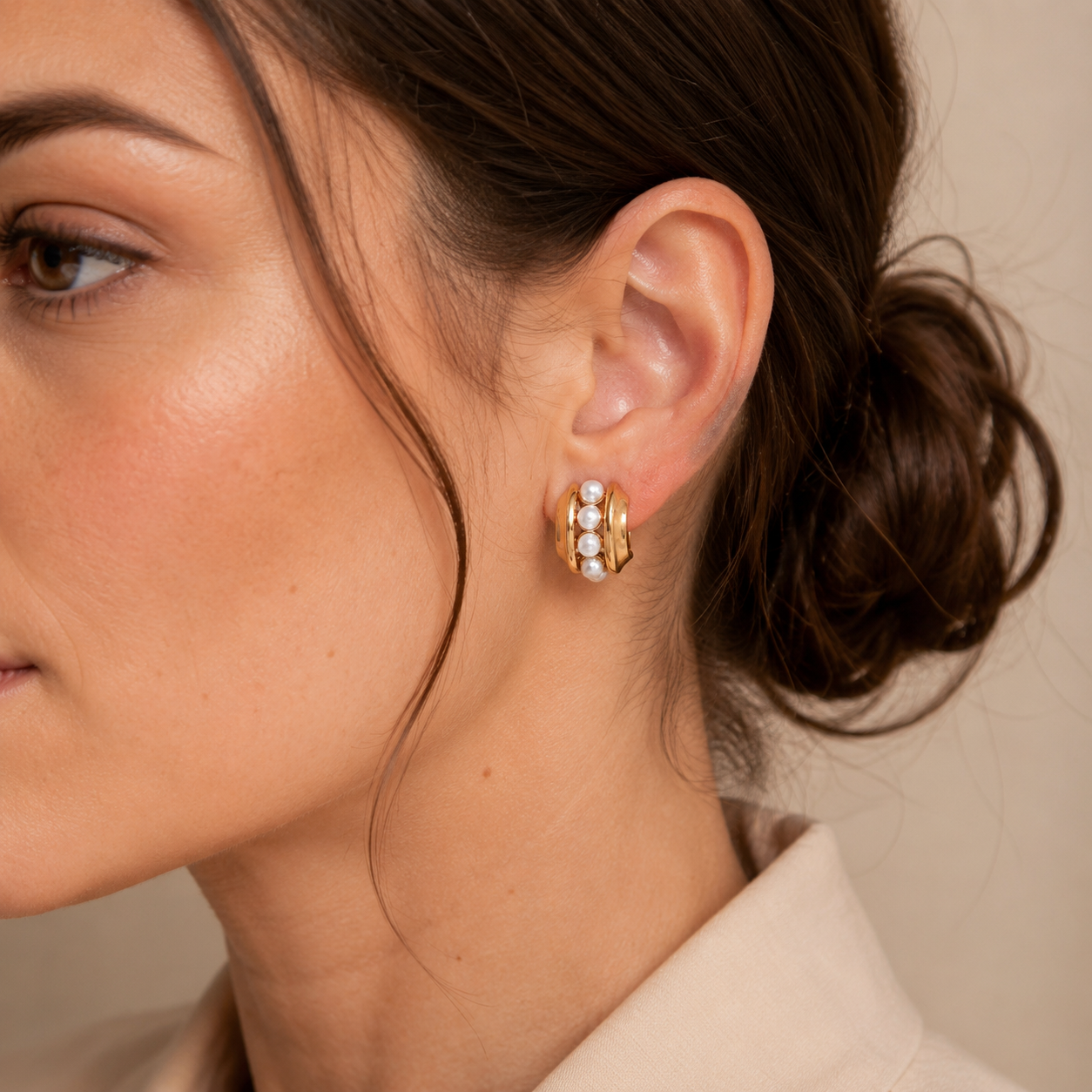 Close ear view of a model wearing Vintage Gold layered shell pearl stud earrings