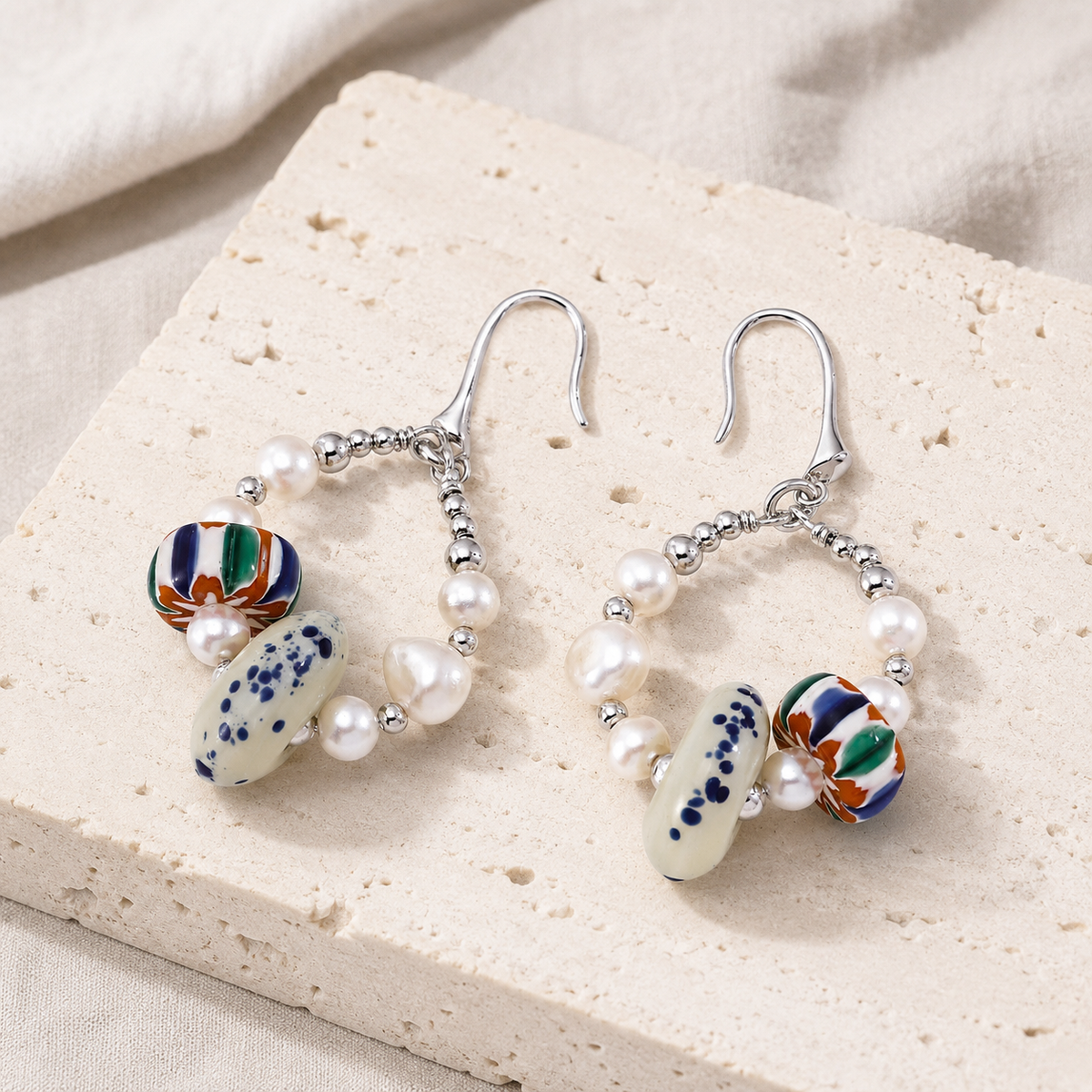 Silver Himalayan Glass Pearl Hoop Earrings on a natural ivory stone display