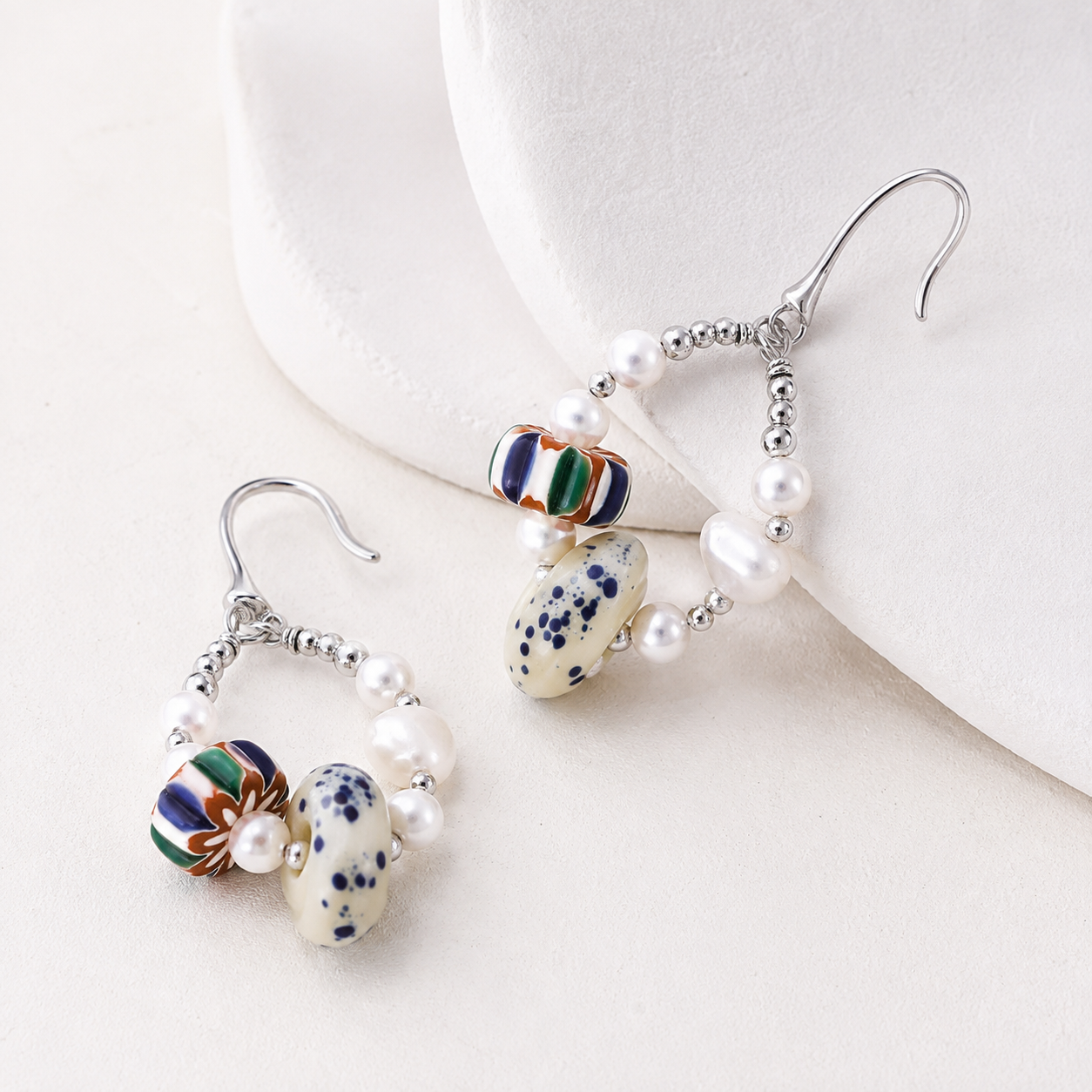 Silver Himalayan Glass Pearl Hoop Earrings on a sculptural ivory display