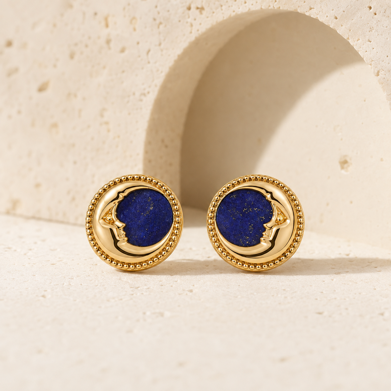 Vintage Gold lapis lazuli moon stud earrings on a stone display