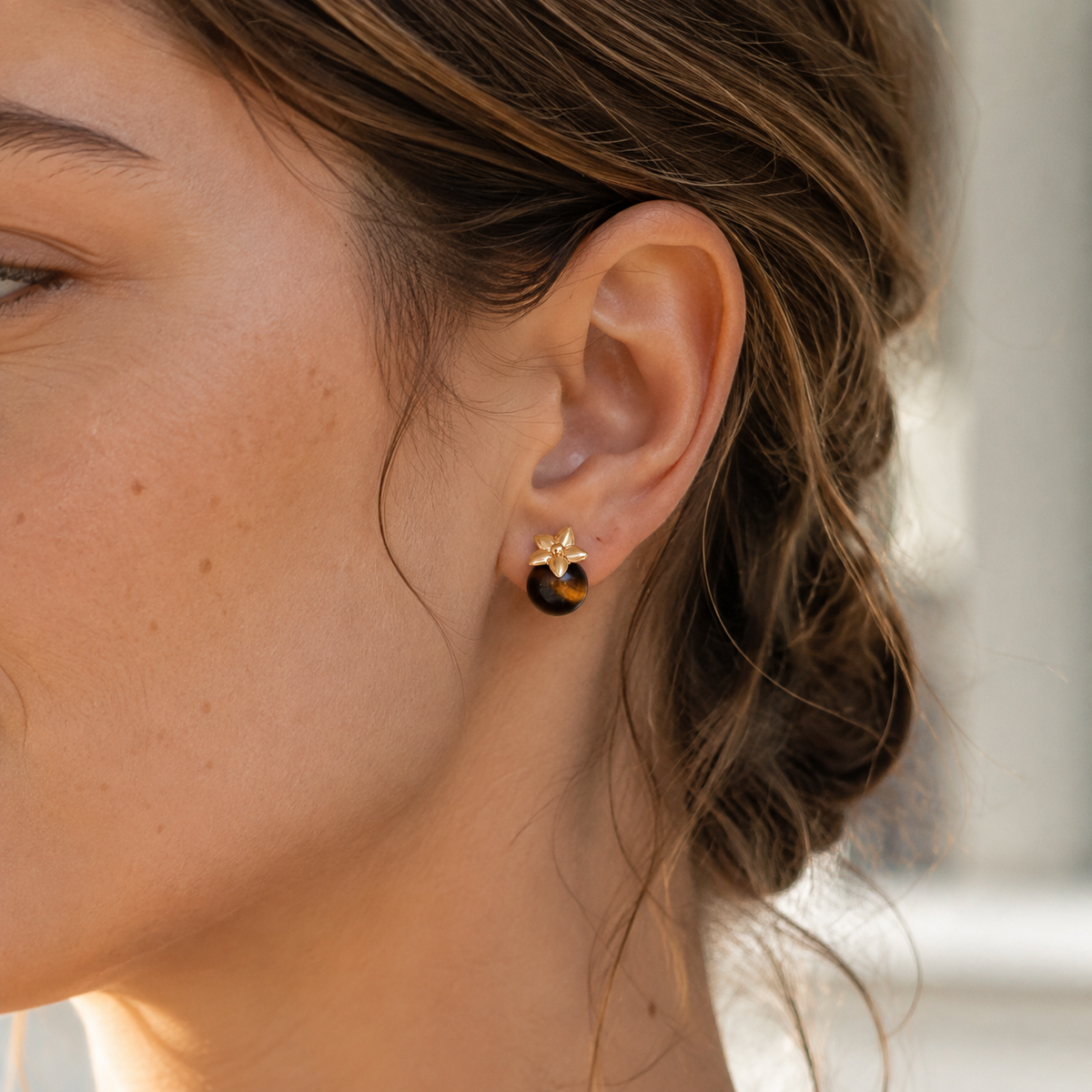 Close ear view of Vintage Gold four-leaf tiger eye stud earrings