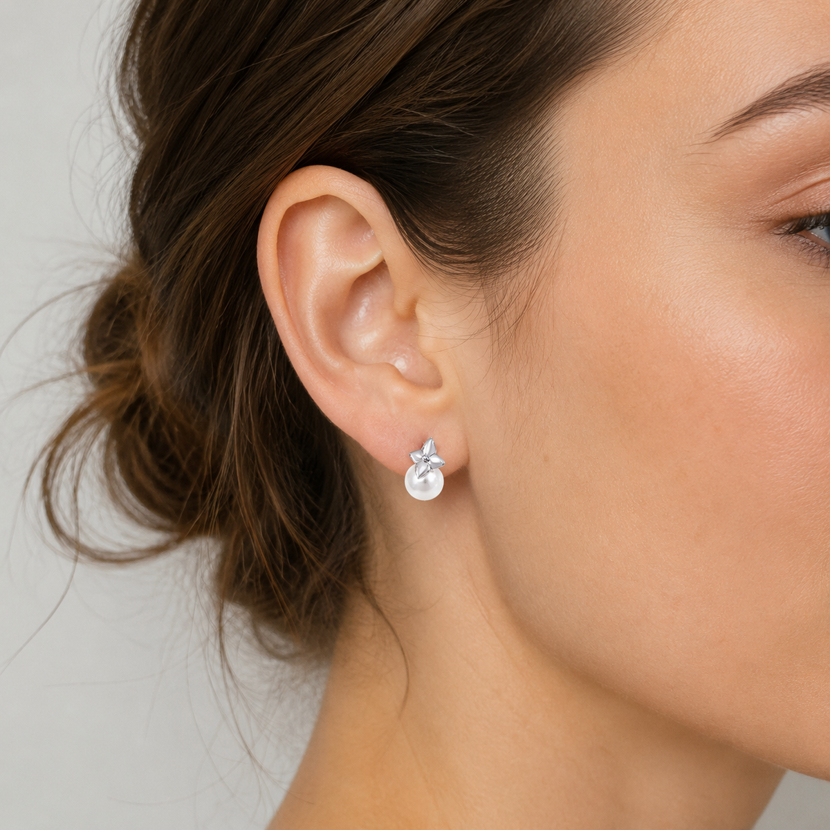 Close ear view of Silver four-leaf shell pearl stud earrings