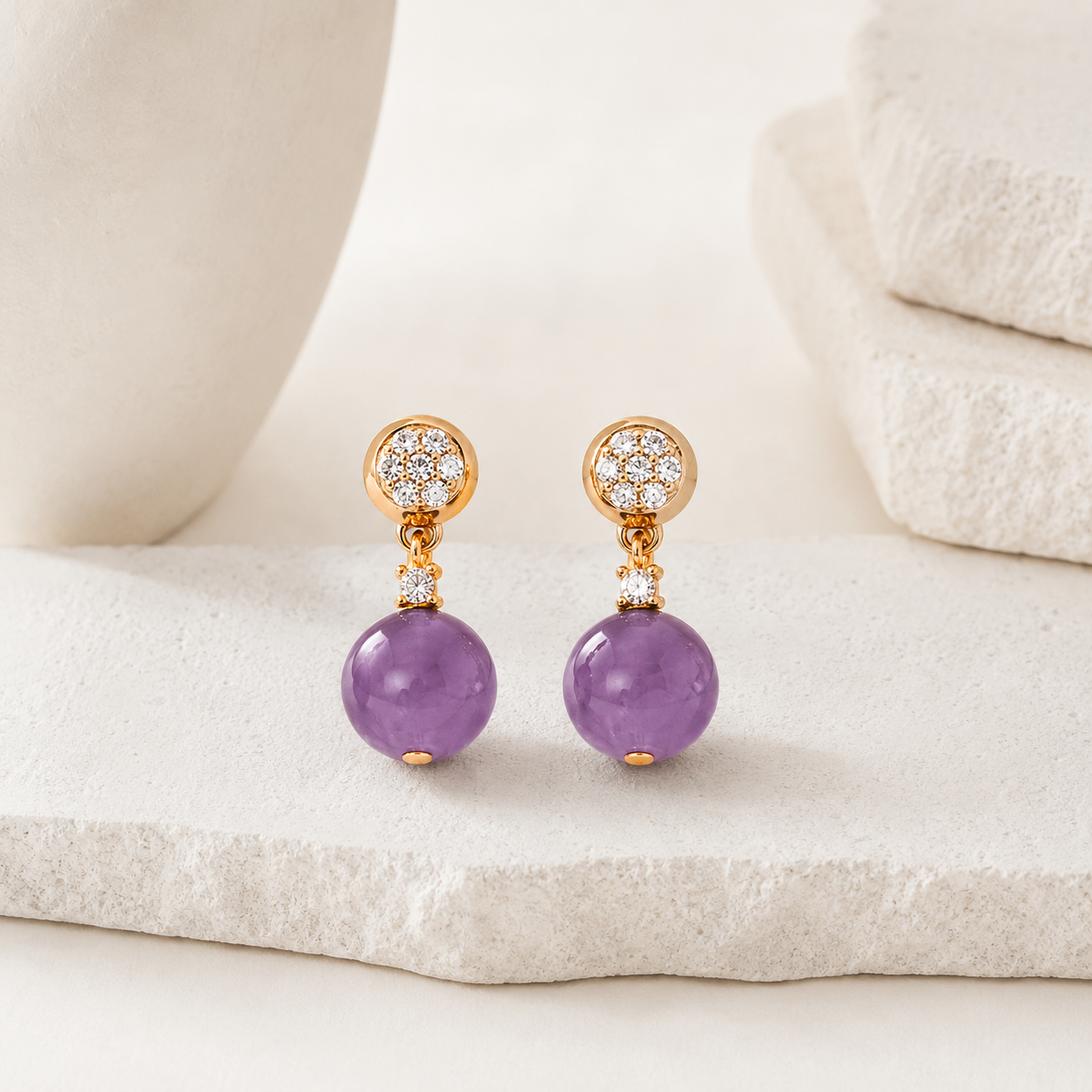 Pair of Vintage Gold Amethyst Drop Earrings with cubic zirconia on an ivory display
