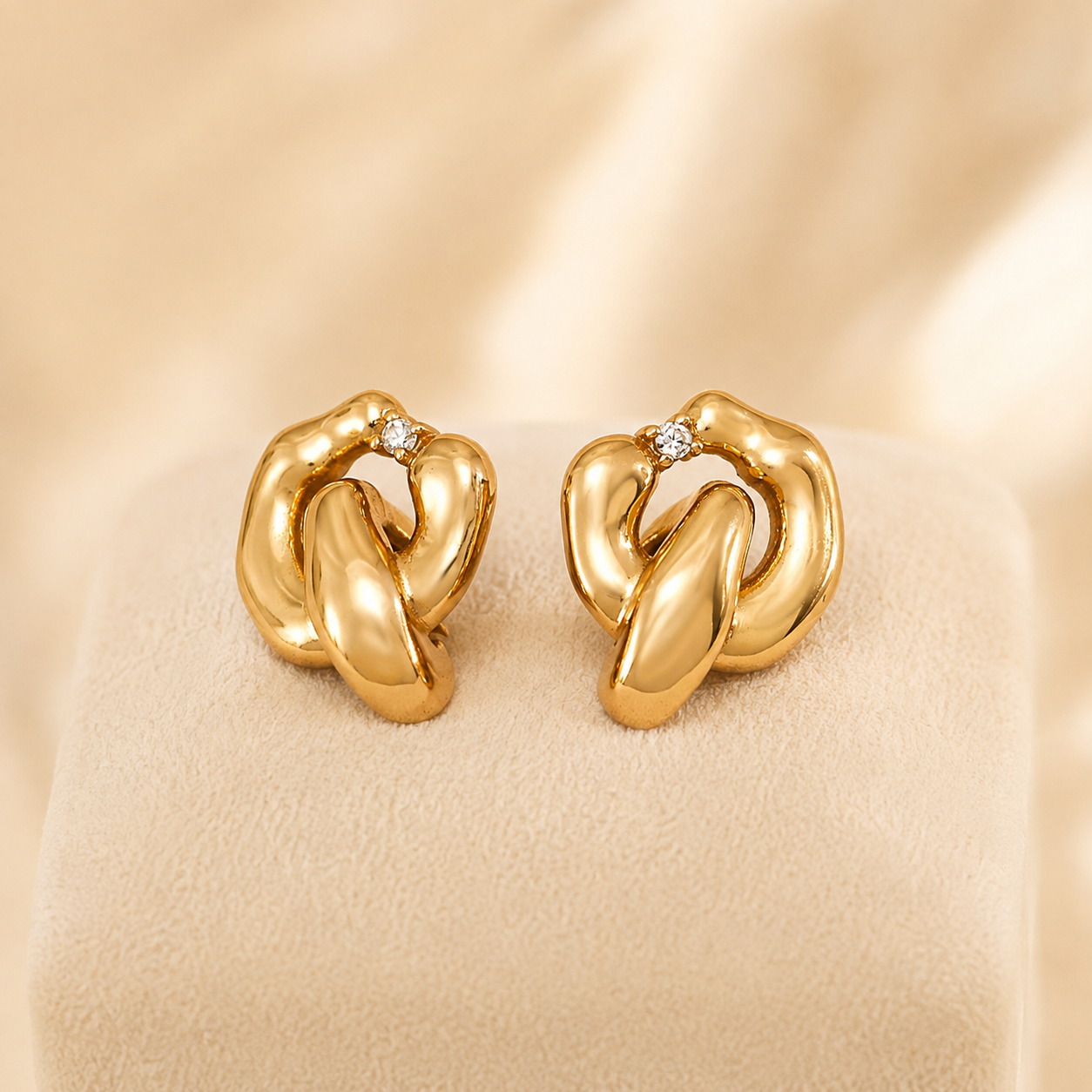 Pair of Vintage Gold Interlocking Zircon Earrings on an ivory display