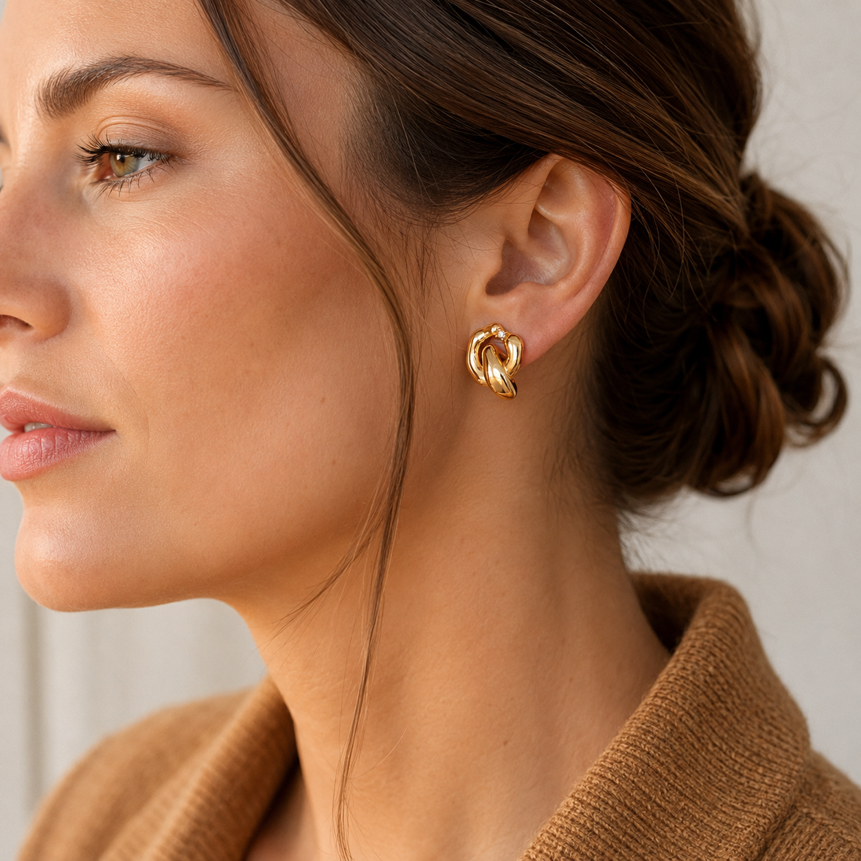 Close ear view of a model wearing Vintage Gold Interlocking Zircon Earrings