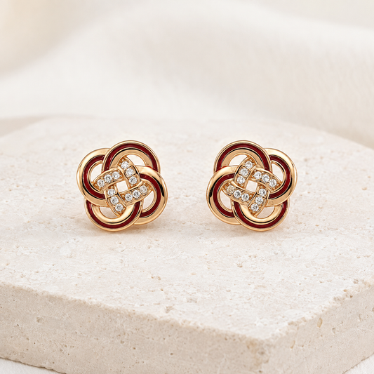 Vintage Gold enamel and cubic zirconia knot stud earrings on an ivory display