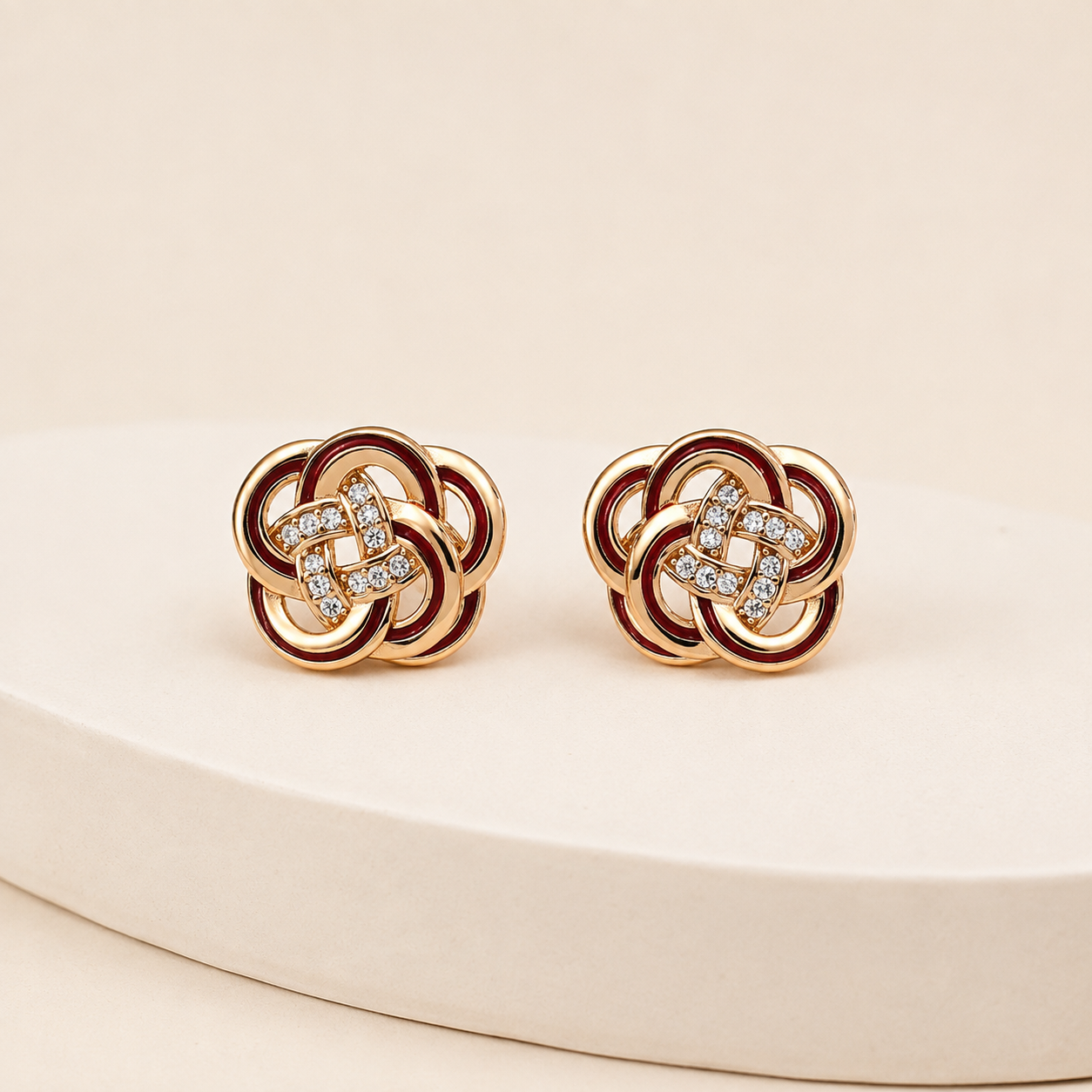 Vintage Gold enamel and cubic zirconia knot stud earrings on an ivory display