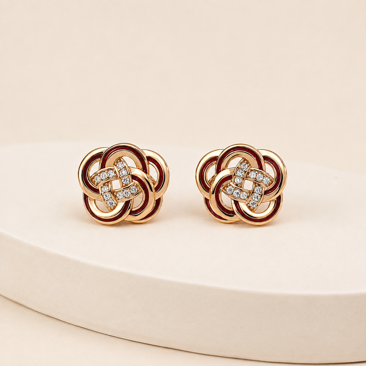 Vintage Gold enamel and cubic zirconia knot stud earrings on an ivory display