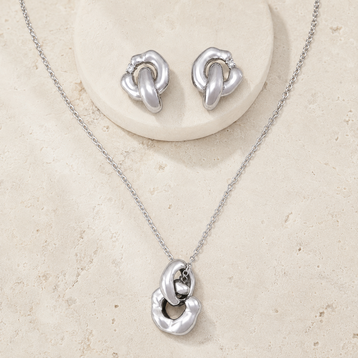 Silver Interlocking Jewelry Set on a stone display