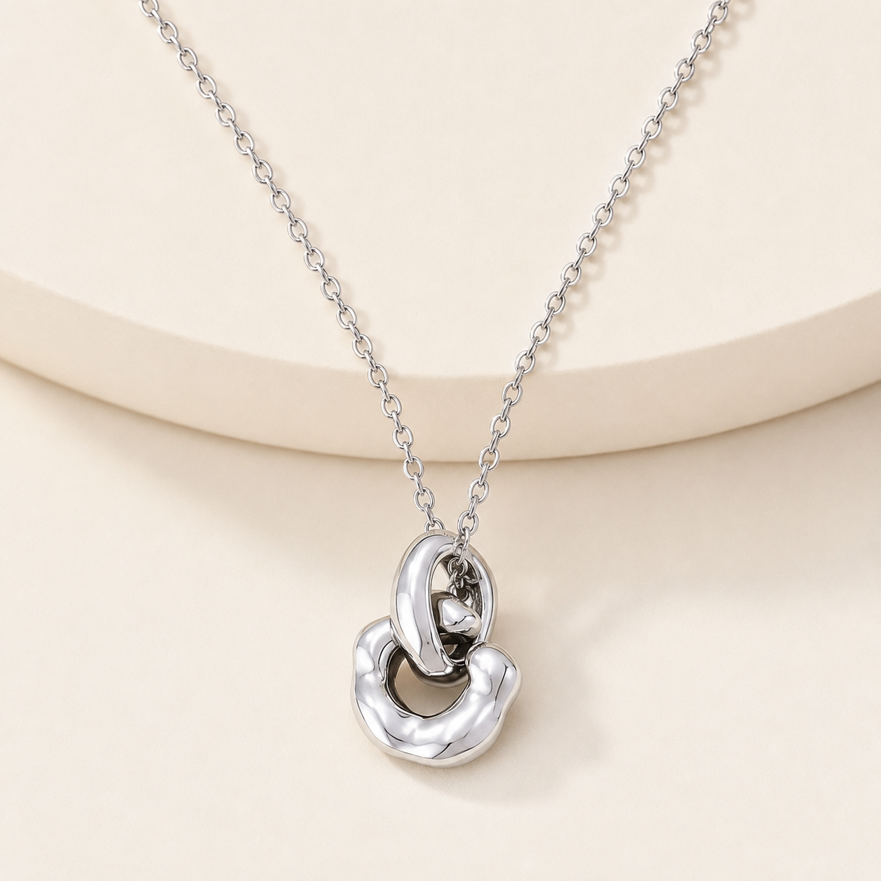Silver Interlocking Pendant Necklace on an ivory display