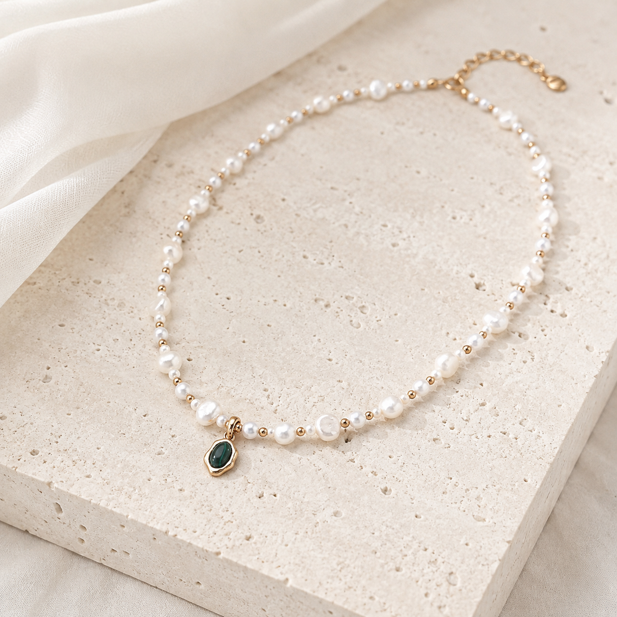 Full view of the Vintage Gold pearl and malachite pendant necklace on a stone display