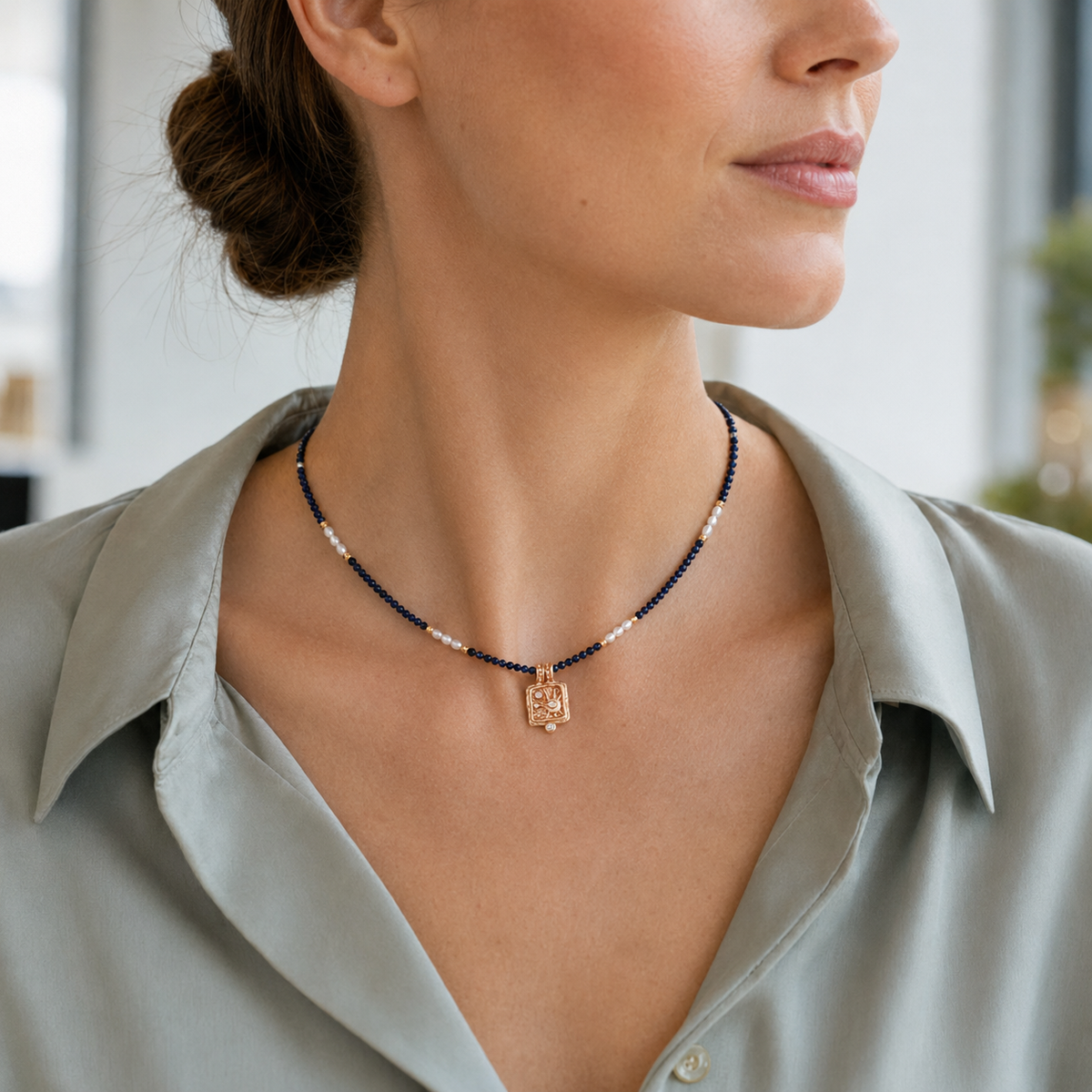 Close neckline view of the Vintage Gold Star Wish Lapis Pearl Necklace with a tailored shirt