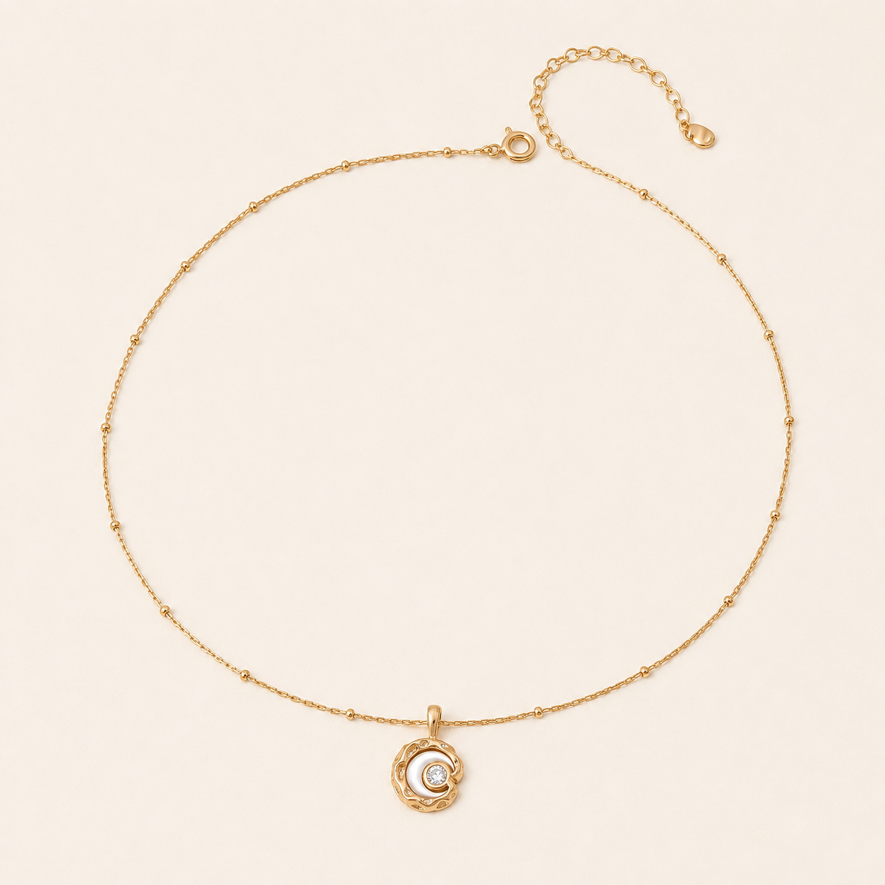 Vintage Gold mother-of-pearl moon pendant necklace on an ivory background