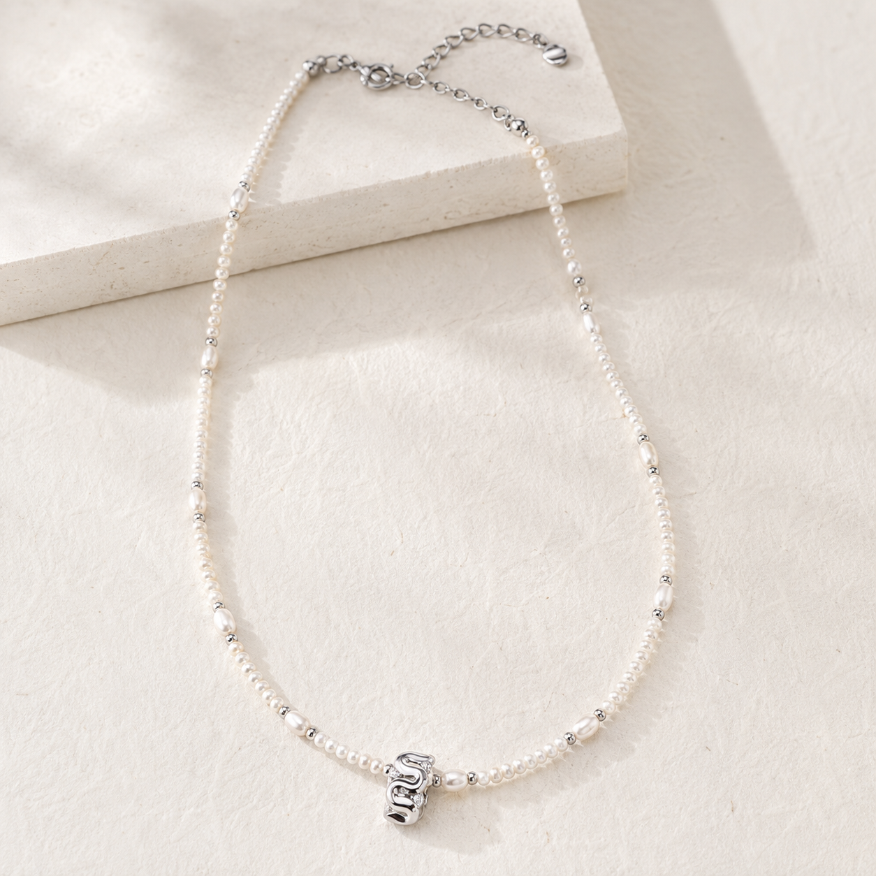 Silver sculpted natural pearl zircon necklace flat lay