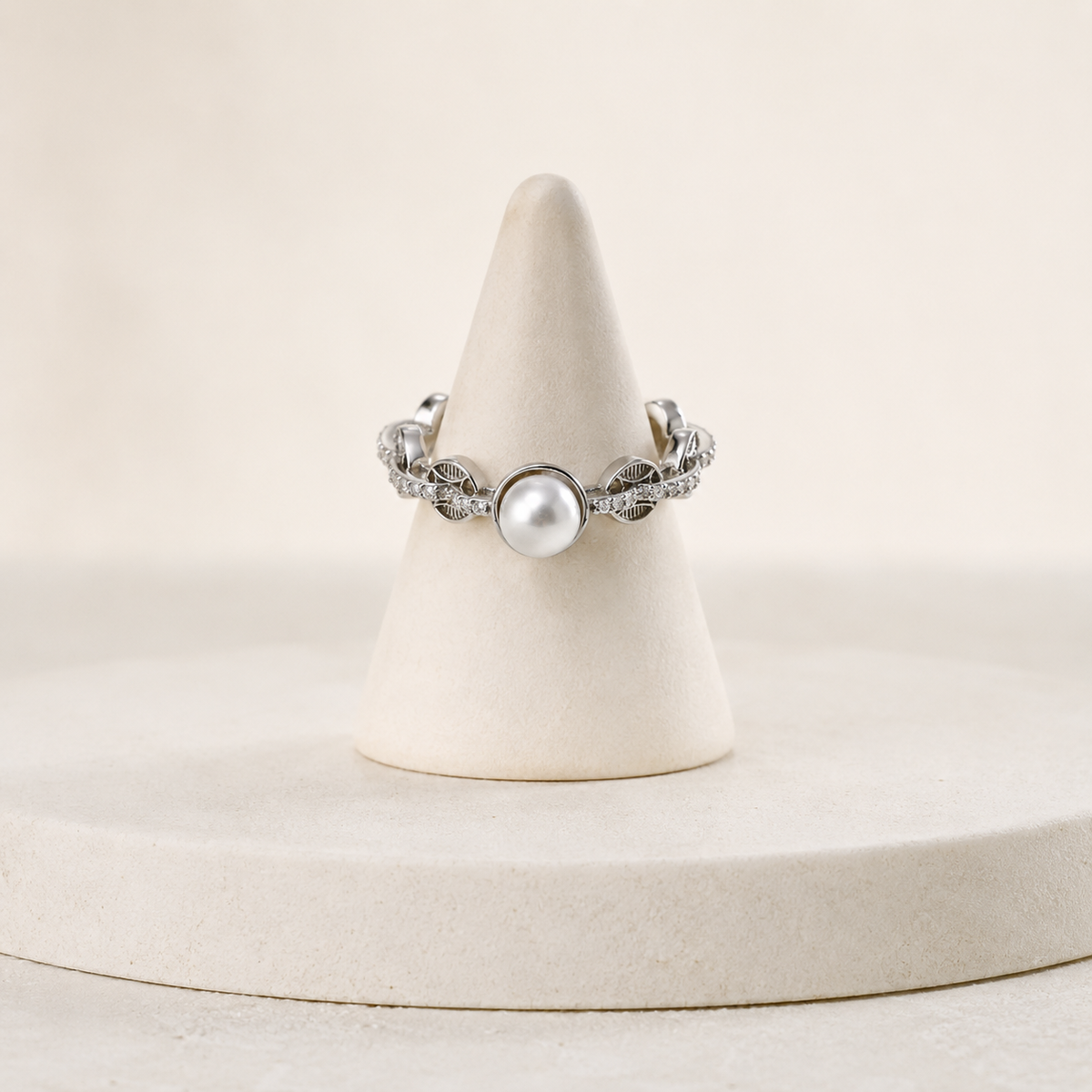 Silver pearl coin motif ring on a ring stand