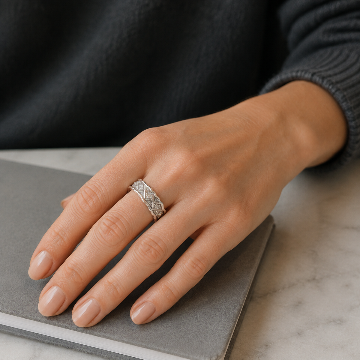 Close hand view of Silver Vintage Zircon Ring on a grey notebook