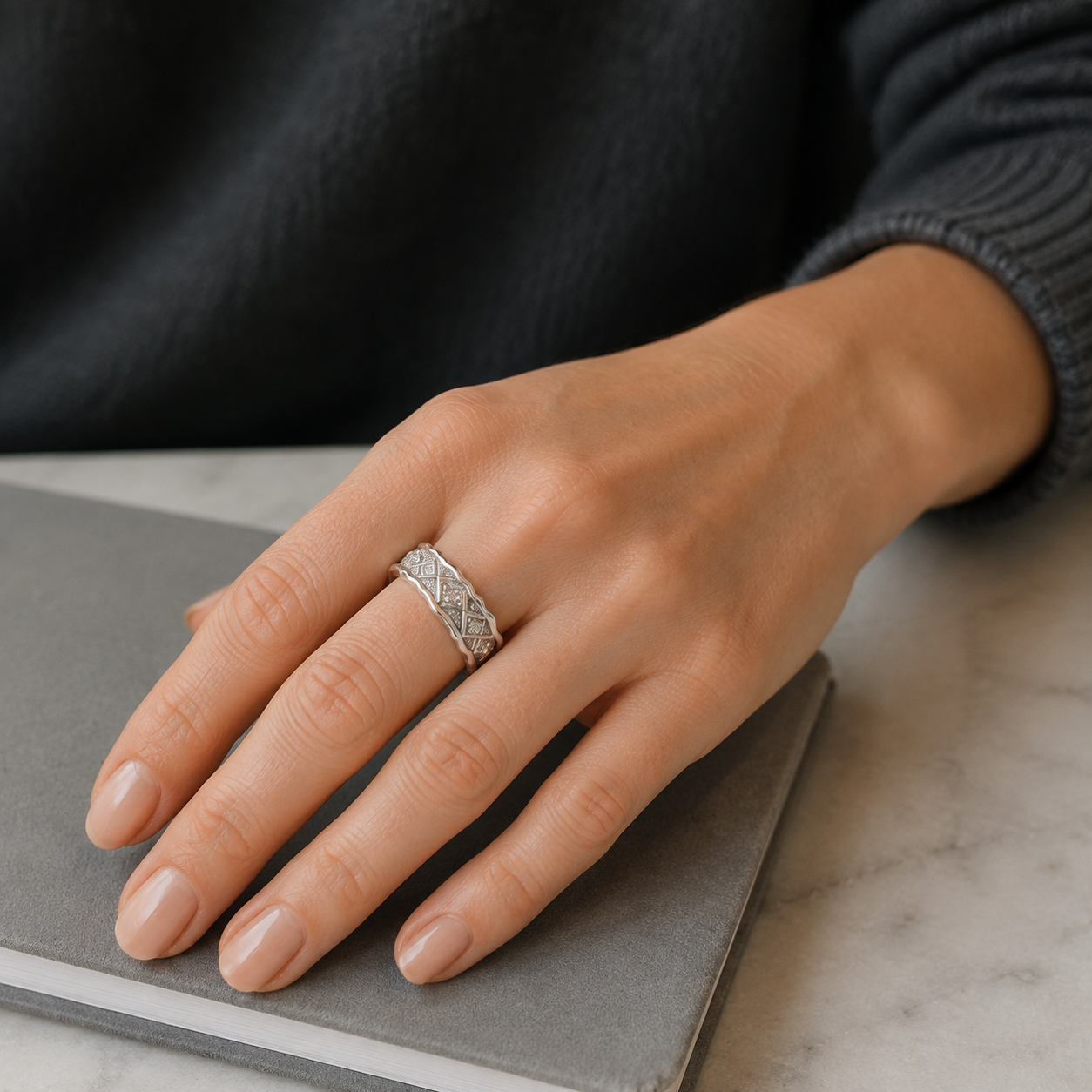 Close hand view of Silver Vintage Zircon Ring on a grey notebook