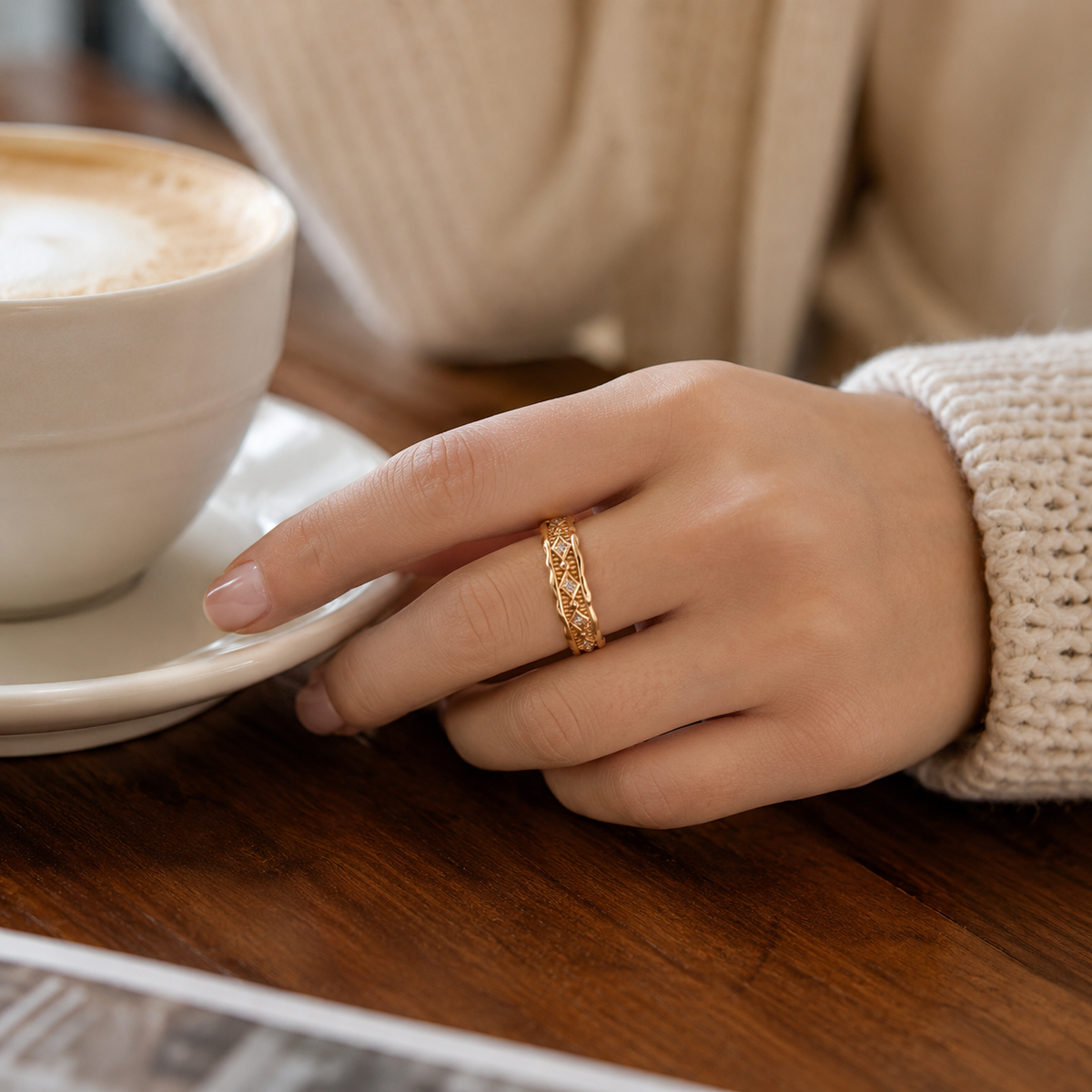 Close hand view of Vintage Gold Vintage Zircon Ring beside a coffee cup